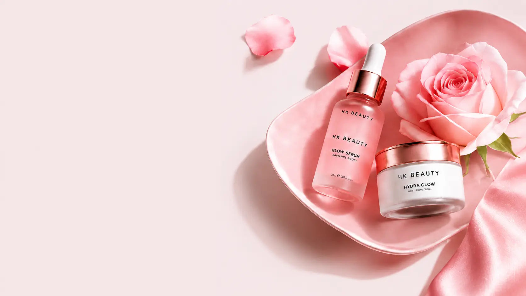 Glow skincare desktop banner featuring serum, face cream, and pink rose for radiant skin.